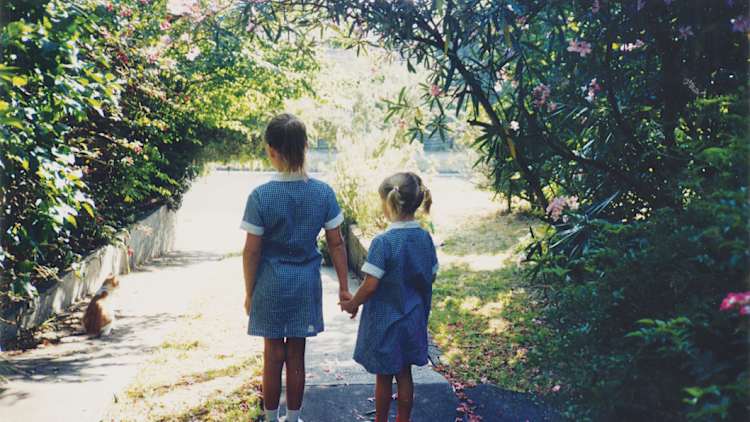 A five-year-old Anna (at right) heading down the driveway for her first day of school, led by her sister, Katie.