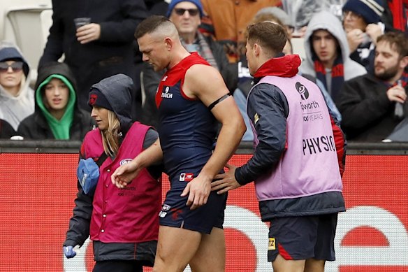 Steven May is helped off after suffering a badly cut face.