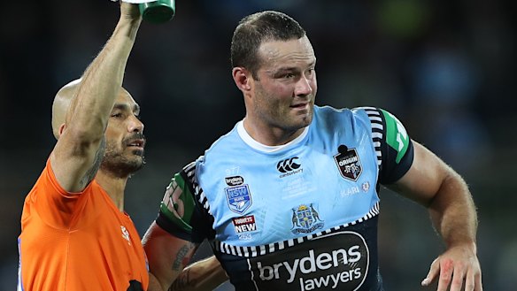 Boyd Cordner is helped from the field by Roosters and Blues trainer Travis Touma.