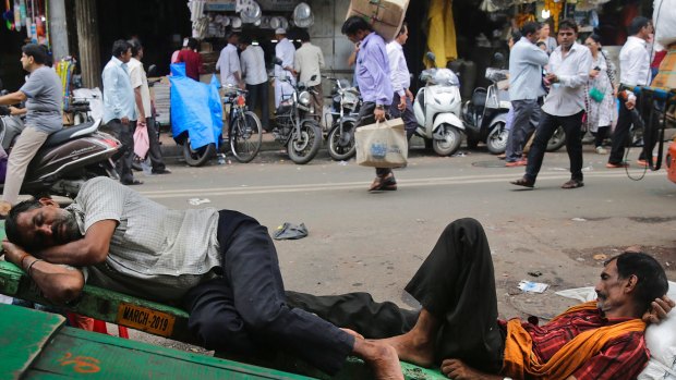 Indian laborers sleep on a handcart in Mumbai, India.
