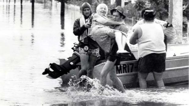 Helpful hands ... rescuers carry an elderly woman to safety during the flood that devastated Brisbane in 1974.