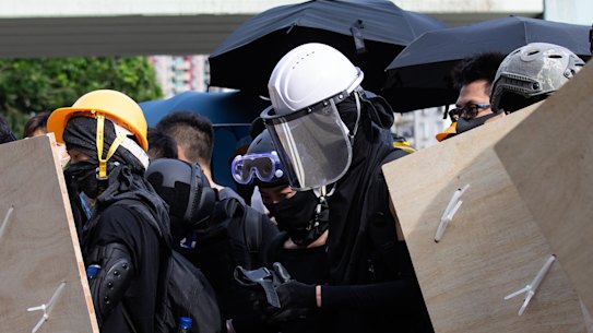 Demonstrators hold makeshift shields and umbrellas during a protest in the Yuen Long district of the New Territories in Hong Kong, China, on Saturday, July 27.