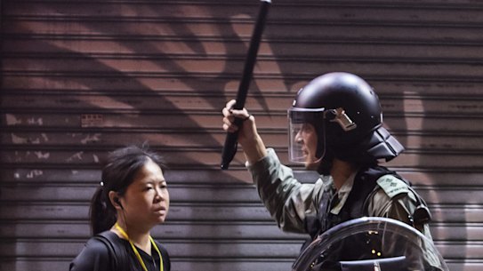 A riot police stands off against a woman during a protest in the Mong Kok district of Hong Kong, China, on Saturday night. 