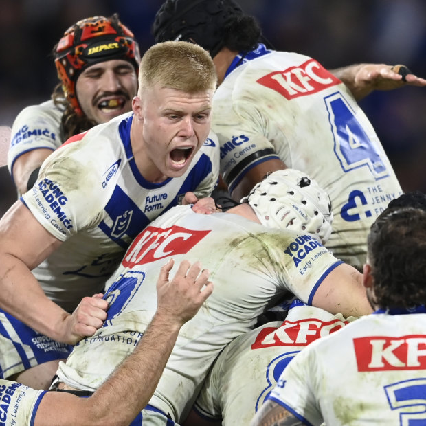 Matt Burton is mobbed by Bulldogs teammates after kicking the winning field goal in golden point.