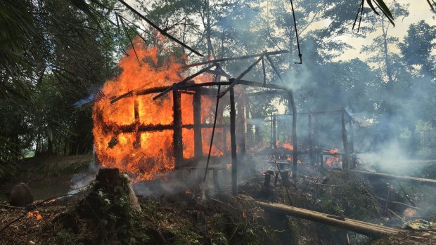 Houses on fire in Gawdu Zara village, northern Rakhine state, Myanmar, where where pages from Islamic texts were seen ripped and left on the ground in 2017.