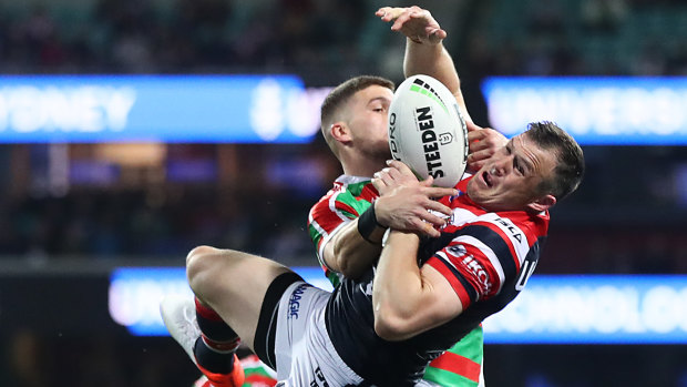 Brett Morris of the Roosters and Adam Doueihi of the Rabbitohs compete for the ball.