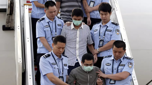 The long reach of Operation Fox Hunt: six accused fugitives are taken back to China under escort from Indonesia in June 2015.
