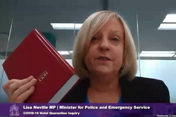 Lisa Neville taking an oath on the Bible before giving evidence at the hotel quarantine inquiry.