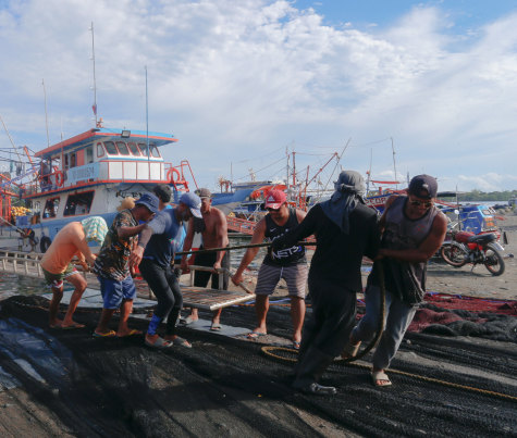 Fishermen unload a trawler in Masinloc.