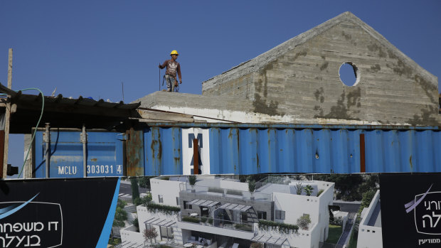 A Palestinian works on a new housing project in the West Bank settlement of Naale.