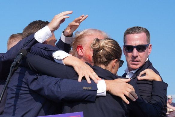 Jabin Botsford’s photo of Trump with a  bloody ear as he is assisted off the stage.