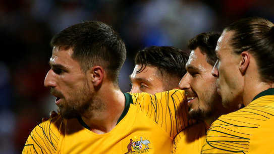 Matthew Leckie of Australia, centre, celebrates with teammates after scoring the Socceroos' opening goal against Kuwait.