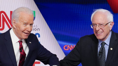 Former Vice President Joe Biden, left, and Senator Bernie Sanders greet each other before they participate in a Democratic presidential primary debate in Washington. 