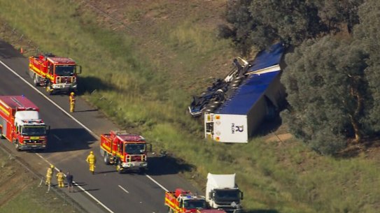 The B-double truck on its side on the opposite side of the freeway to which it was travelling.