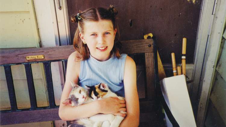 Anna, aged 11, with some kittens on a visit to the Iowa farm where her mother grew up.