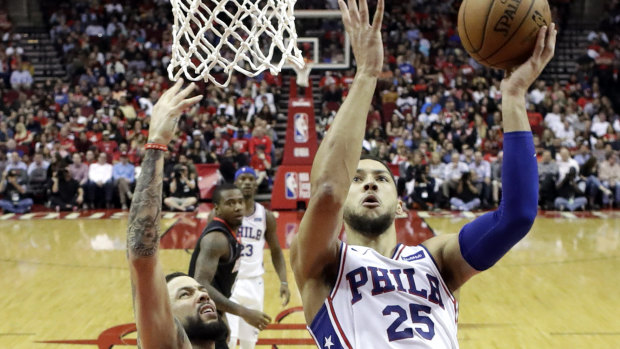 Philadelphia 76ers' Ben Simmons, right, goes up to shoot as Houston Rockets' Austin Rivers defends.