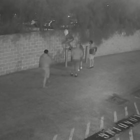 NRL player Manase Fainu, pictured with a white towel on his head, jumping a fence onto church grounds.