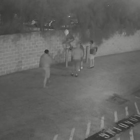 NRL player Manase Fainu, pictured with a white towel on his head, jumping a fence onto church grounds.