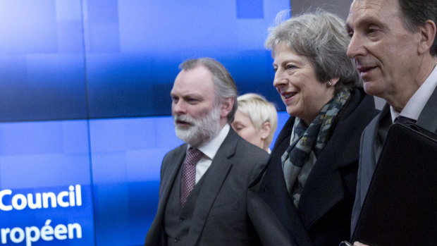 Theresa May, centre, and British Ambassador to the EU Sir Tim Barrow, left, leave the Europa building in Brussels on Tuesday.