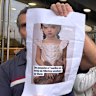 A protester holds a picture of a childlike sex doll outside the new Shein store at BHV Marais in Paris.