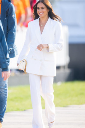On day one, Meghan wore a white pant suit from Valentino.    