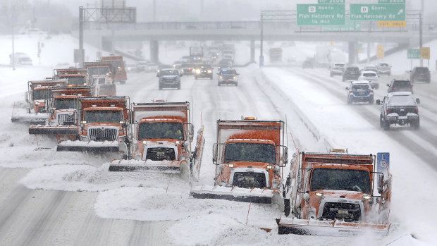 Snow plows move along a highway in Madison, Wisconsin.
