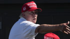 Donald Trump throws autographed red hats to the crowd during a LIV golf tournament this month. 