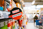 A high-protein sign in a supermarket aisle