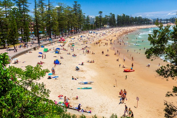 Manly Beach on a sunny, Sunday morning, with tourists and sightseers enjoying the water
