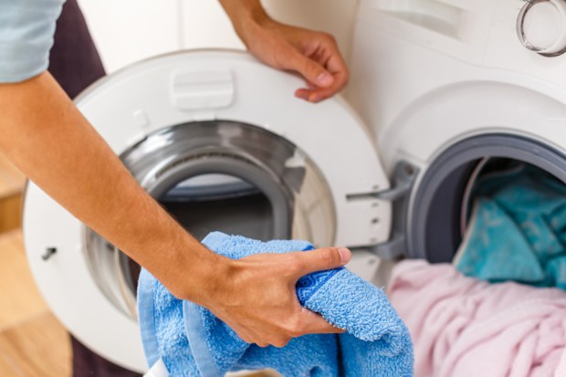 Man loading towels into the washing machine.