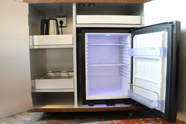 A hotel room with a mini fridge 