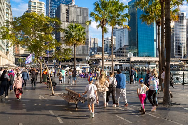 Crowd of people at Circular Quay Sydney. With the CBD buildings in the background.
