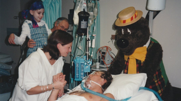 Andrew Taylor is visited in hospital by his sister Jenny (in surgical gown), terminally ill niece Emily and Humphrey B. Bear. 