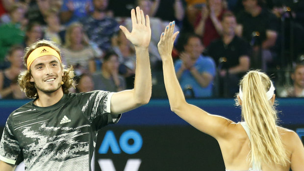 Stefanos Tsitsipas of Greece high fives Caroline Wozniacki of Denmark.