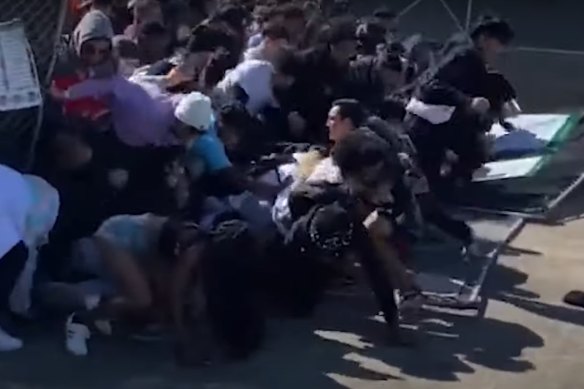 A still from US television shows the crowd rushing through the gates towards the stage. 