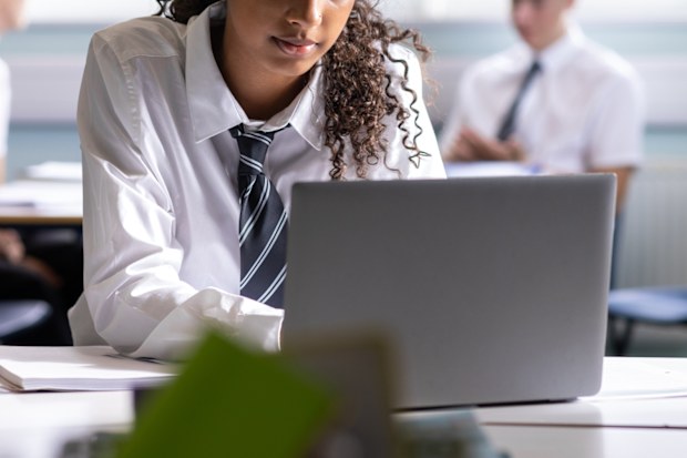 Stock image of a school student using a laptop