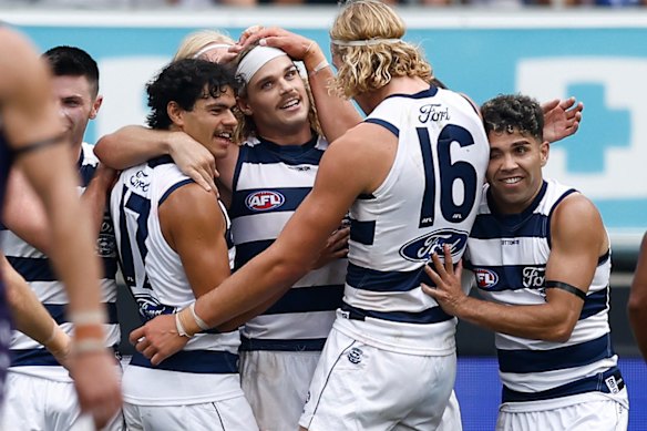 Bailey Smith (centre) celebrates a goal with his Geelong teammates.