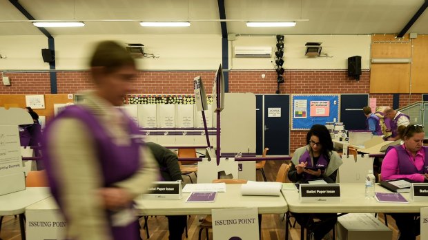 Australian electoral commission staff prepare for voters to arrive minutes before the Blacktown South Public School opens so people can vote in the Australian Federal election in 2016
