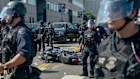 Law enforcement officers surround a motorcycle on the ground during a demonstration in Los Angeles.