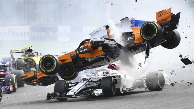 Spectacular: Fernando Alonso's McLaren flies over Sauber's Charles Leclerc in Belgium.