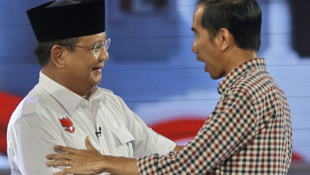 Joko Widodo, now Indonesia's President, shakes hands with his then opponent Prabowo after a 2014 debate.