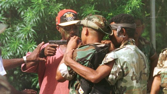 Corporal Allen, bodyguard of the sacked military commander, Brigadier-General Singirok, pulls his pistol on one of four soldiers who arrived at Murray Barracks in Port Moresby yesterday morning reportedly asking for food. 