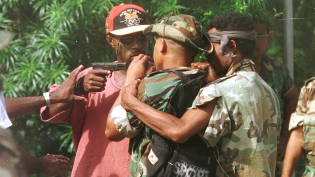 Corporal Allen, bodyguard of the sacked military commander, Brigadier-General Singirok, pulls his pistol on one of four soldiers who arrived at Murray Barracks in Port Moresby yesterday morning reportedly asking for food. 