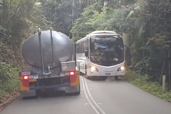 A water carrier passes a tourist bus on Tamborine Mountain.
