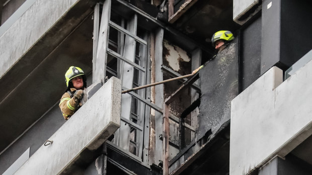 Firefighters inspect the damage at the Neo200 tower.