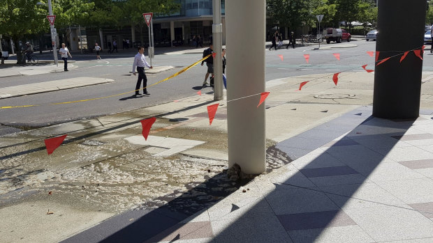 Sewage is seen flowing from a building's pier on Moore Street in Canberra city.