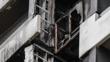 Firefighters inspect the damage at the Neo200 tower.
