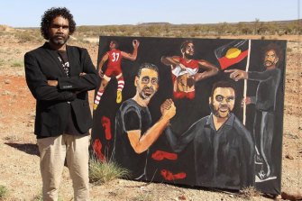 Vincent Namatjira with his 2020 Archibald Prize-winning portrait of Adam Goodes.