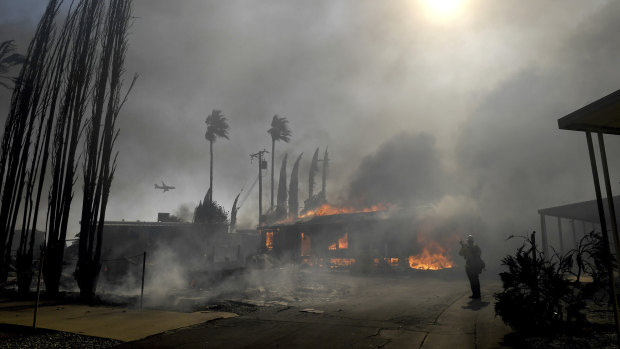 Firefighters battle the Sandalwood Fire as it destroys homes in the Villa Calimesa Mobile Home Park in Calimesa, California. 