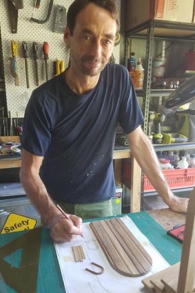 Mace Robertson in his workshop, remaking one of the stolen tiny doors.